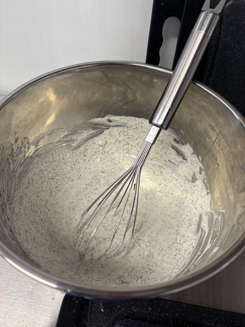 Homemade dill ranch being whisked in a steel bowl